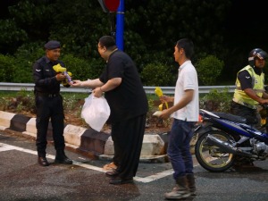Appreciating their effort, Rinpoche make sure they have hot drinks while they work to clear the landslide in Bentong
